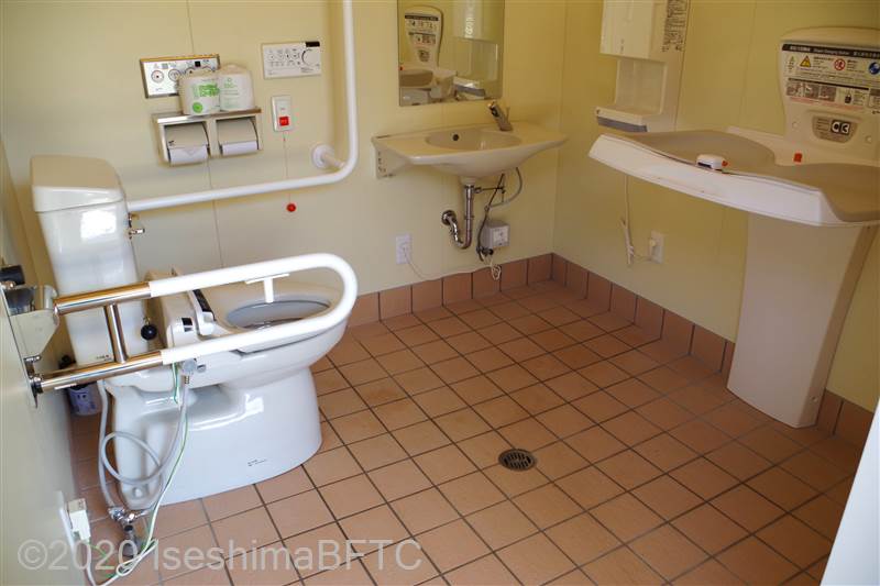 神明神社車いす対応トイレ内部　入口からみて正面奥に、よこ置きに便器。入口からみて右奥に洗面台